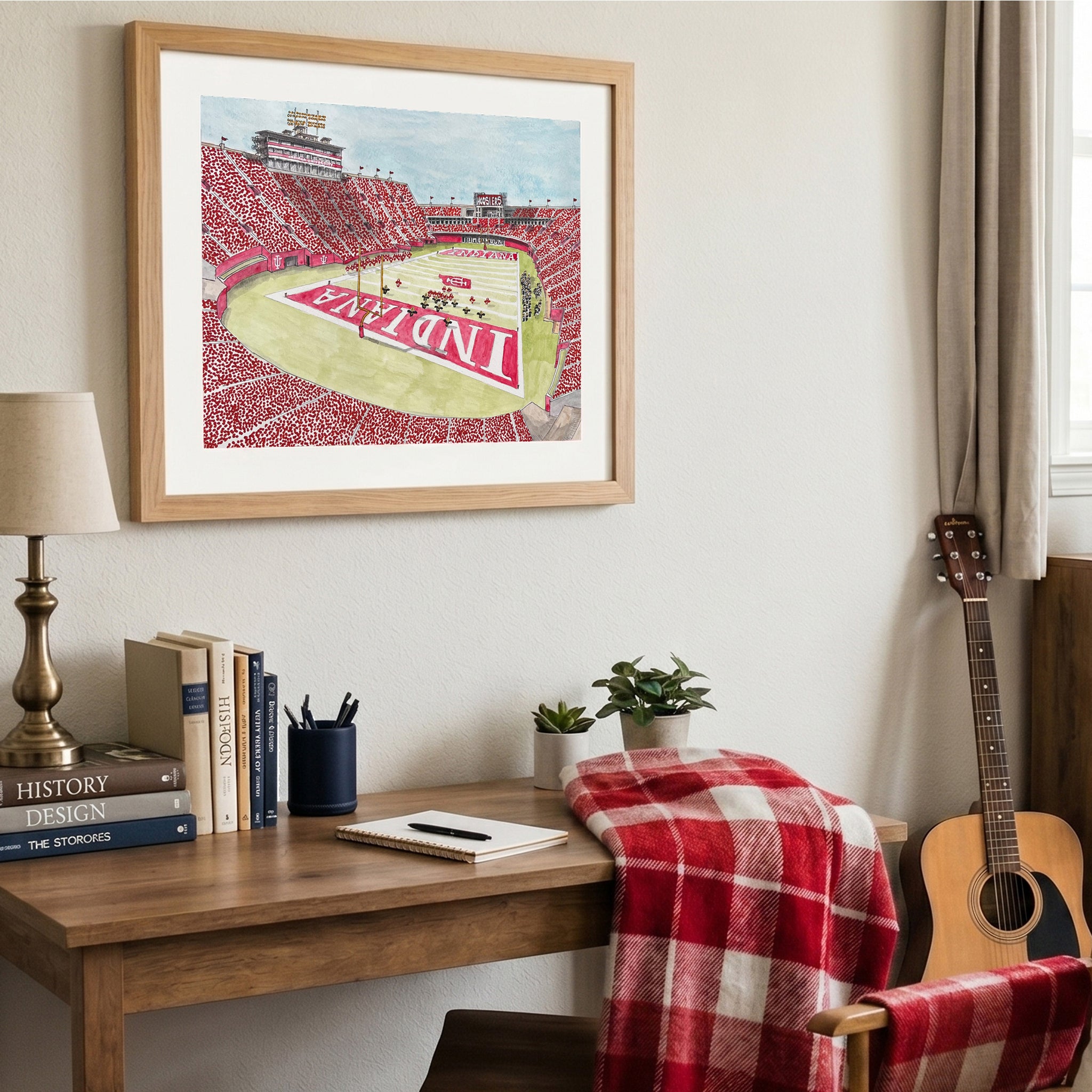 Watercolor print of Indiana football stadium above a desk in a dorm room.
